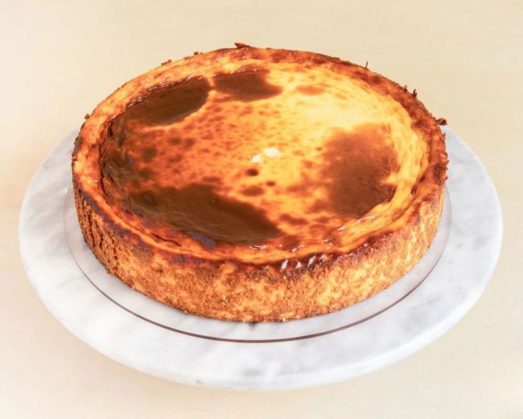 Cheesecake No tan clásica entera, con la superficie dorada y manchas de caramelo