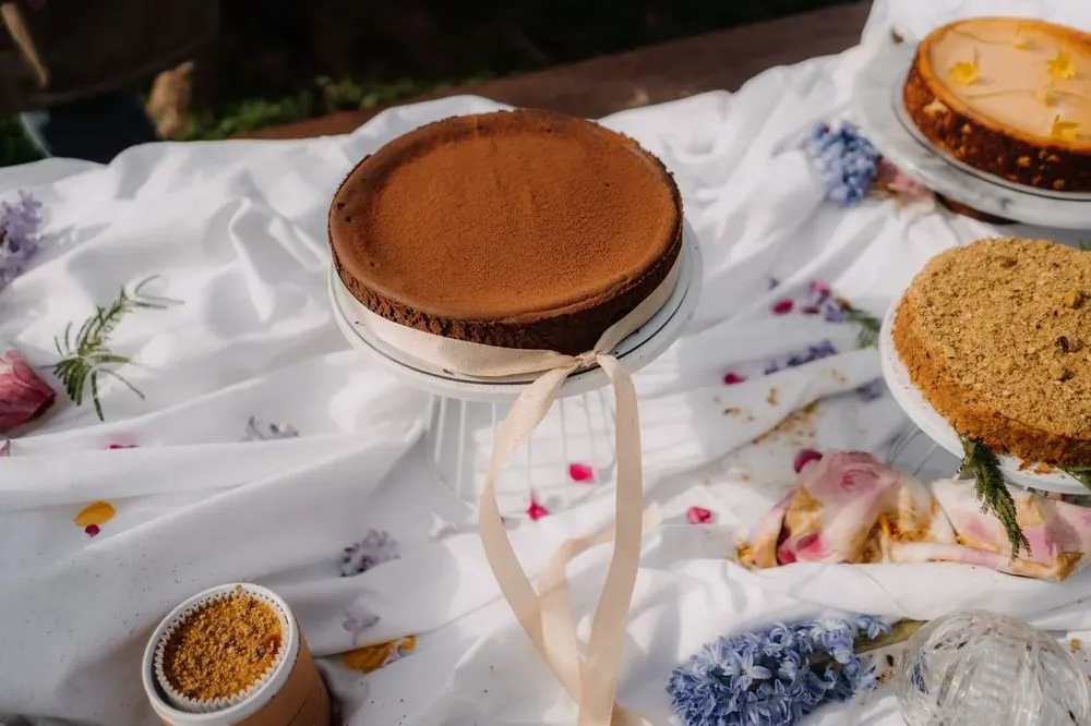 Cheesecakes de CHICA sobre un mantel blanco con flores en una celebración