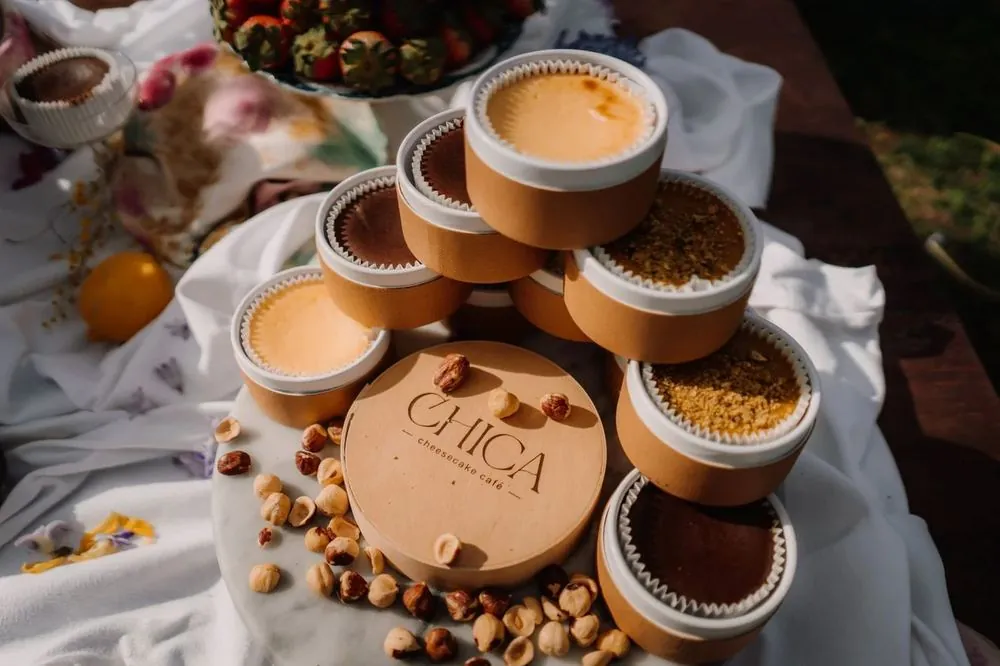 Torre de cheesecakes mini de CHICA en sus cajitas, con la caja de madera del logo