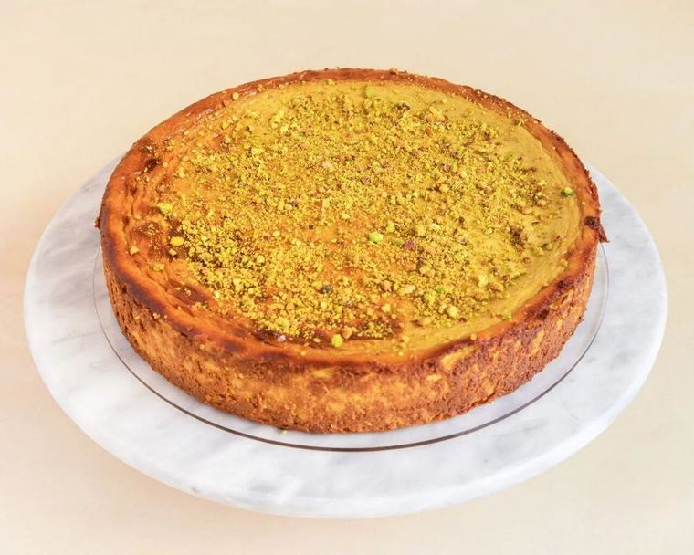 Cheesecake de pistacho entera, con pistacho picado por encima